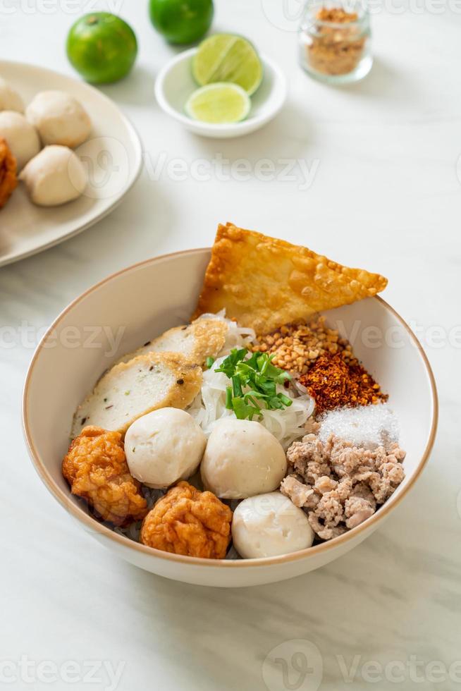 kryddiga små platta risnudlar med fiskbollar och räkbollar utan soppa - asiatisk matstil foto