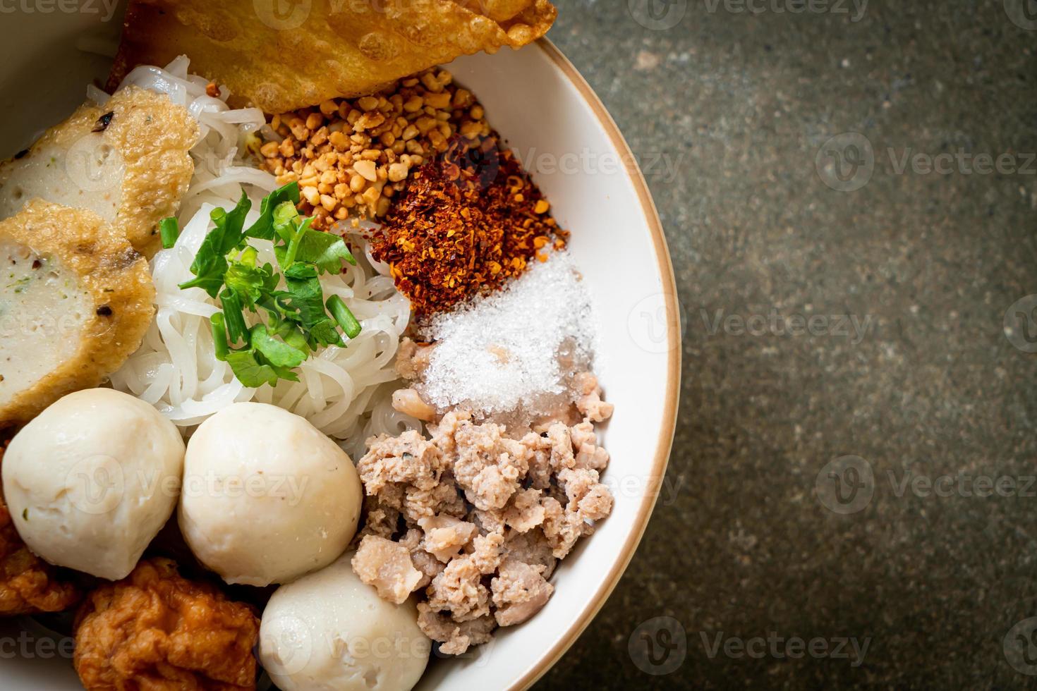 kryddiga små platta risnudlar med fiskbollar och räkbollar utan soppa - asiatisk matstil foto