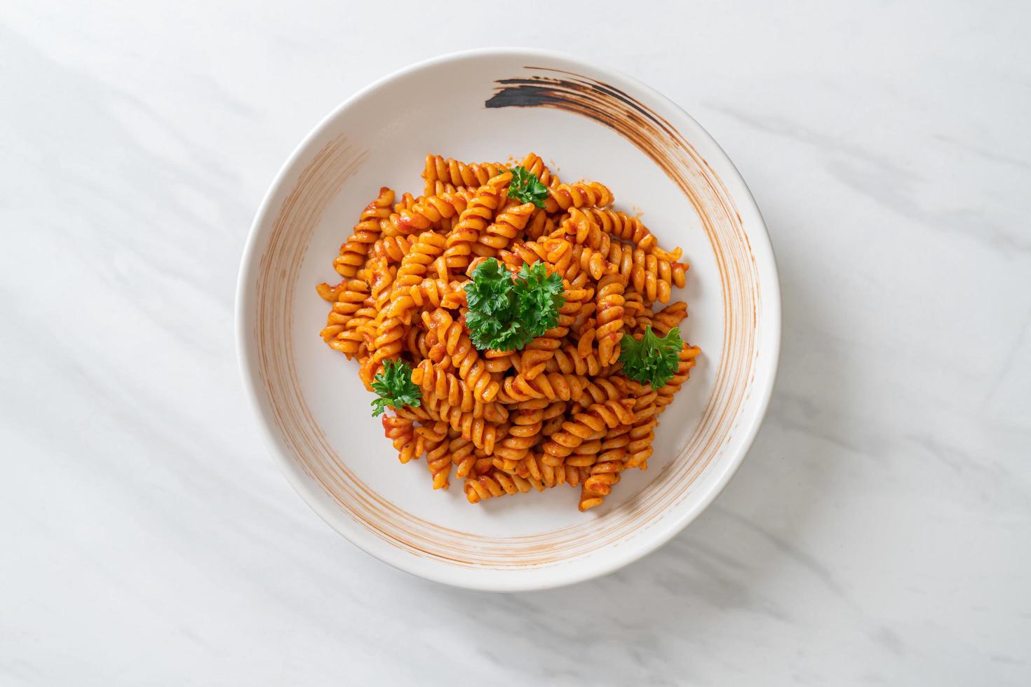 spiral- eller spiralipasta med tomatsås och korv - italiensk matstil foto