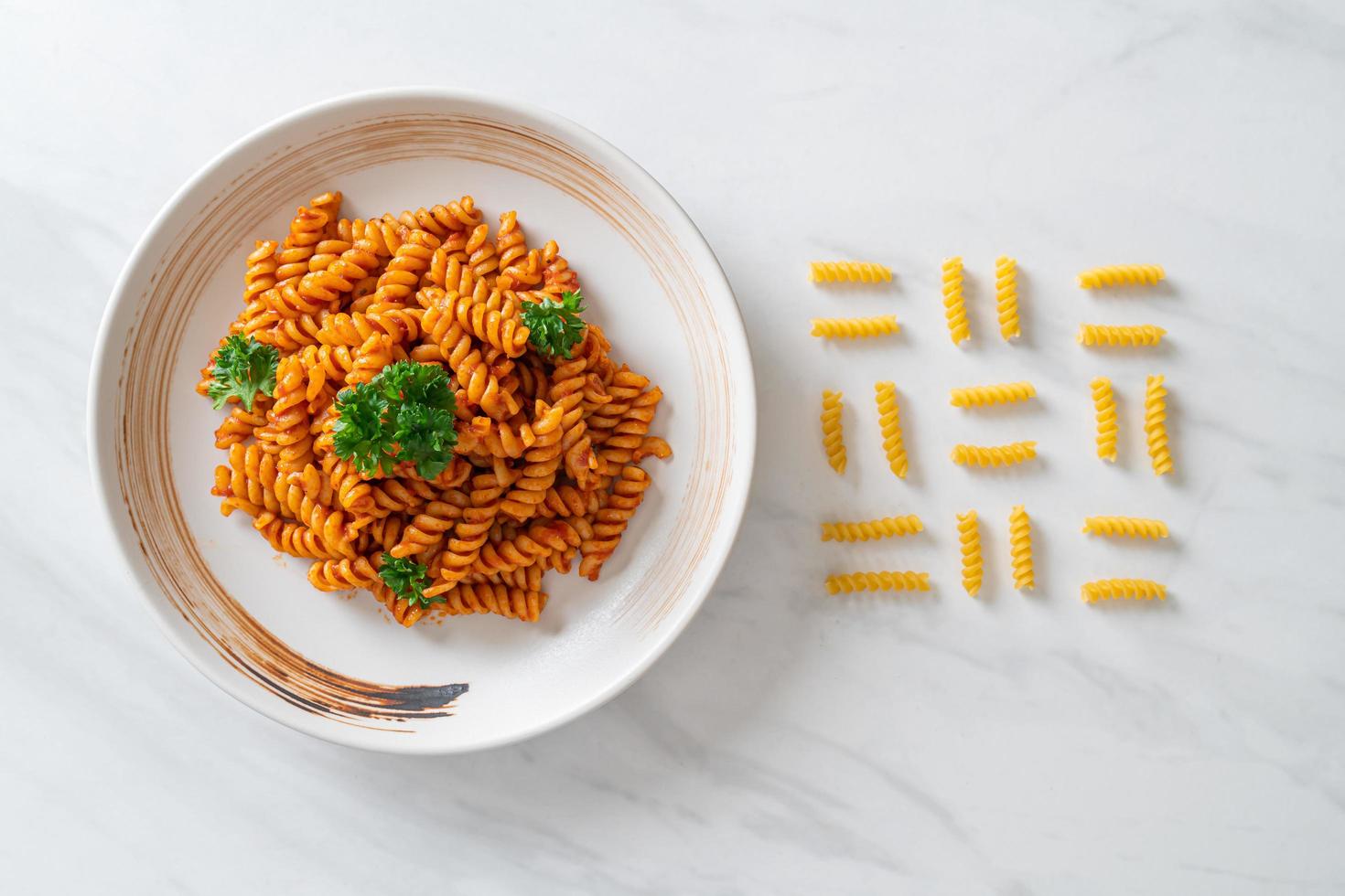 spiral- eller spiralipasta med tomatsås och korv - italiensk matstil foto