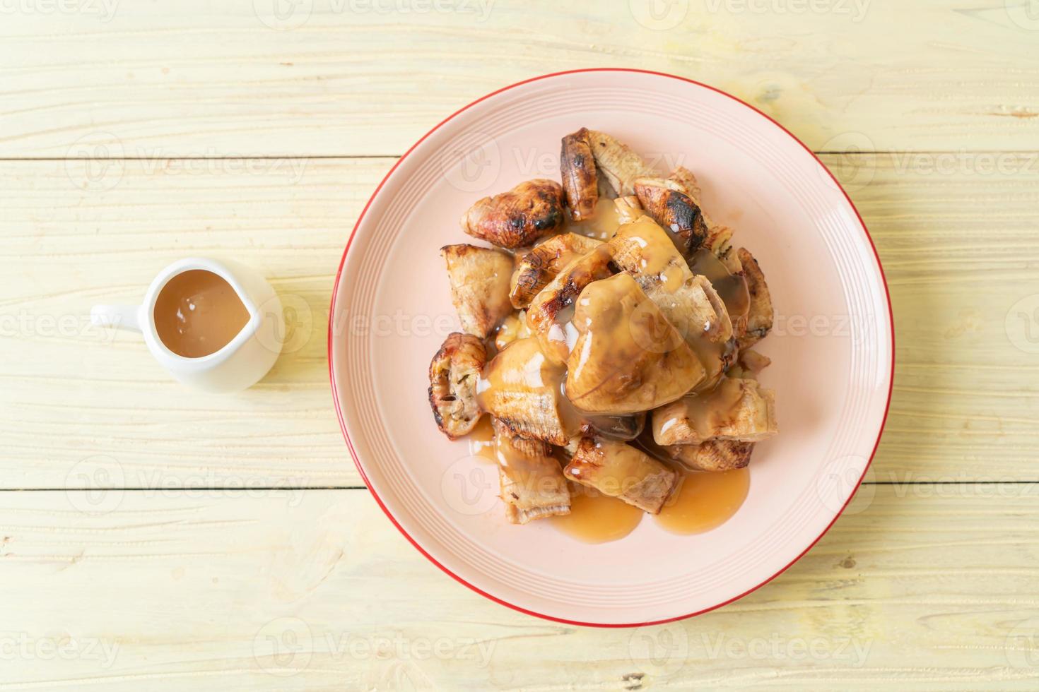 grillade bananer med kokosnötsamelsås på tallriken foto