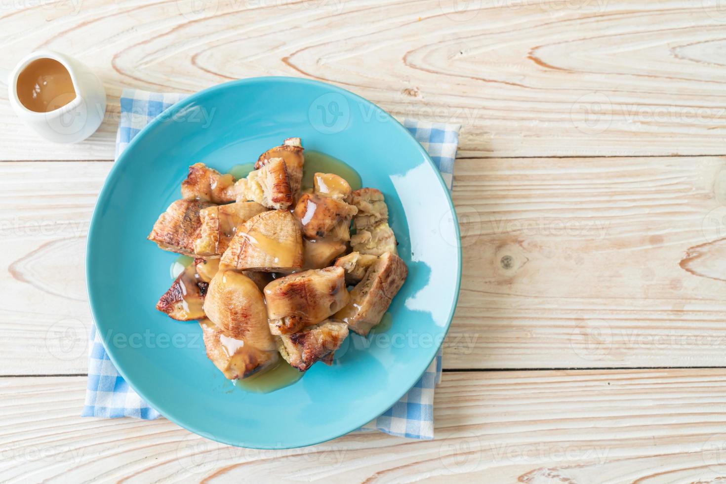 grillade bananer med kokosnötsamelsås på tallriken foto