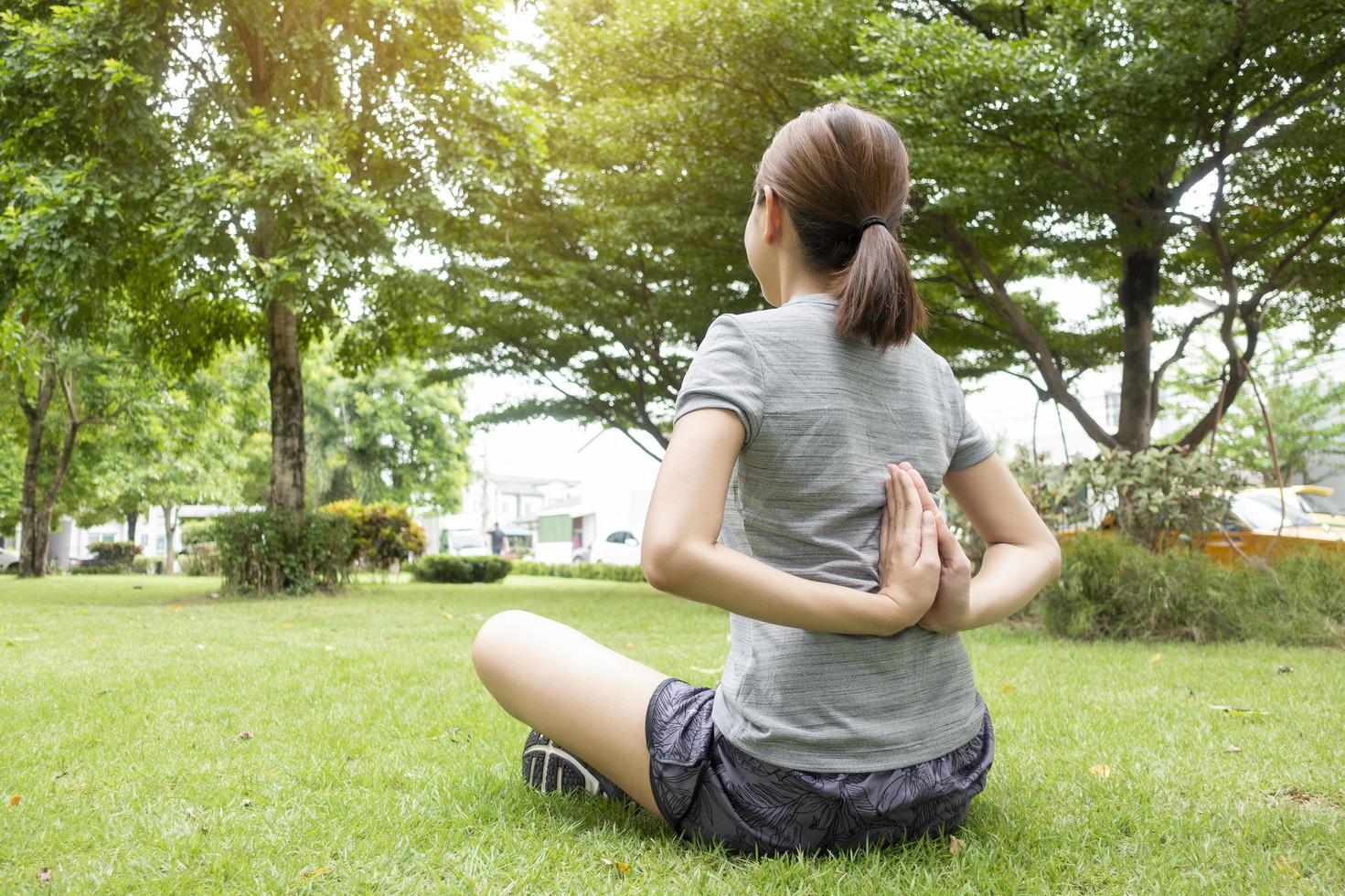 närbild av kvinna som gör yoga i grön trädgård foto