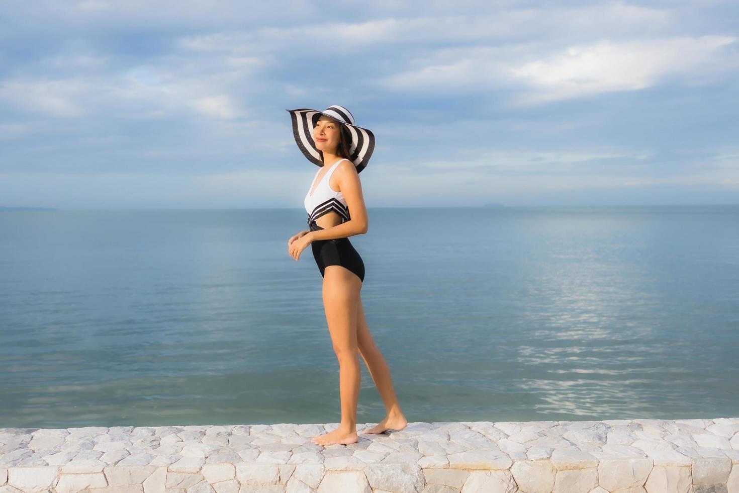 porträtt vackra unga asiatiska kvinnor koppla av leende glad runt havet stranden havet foto