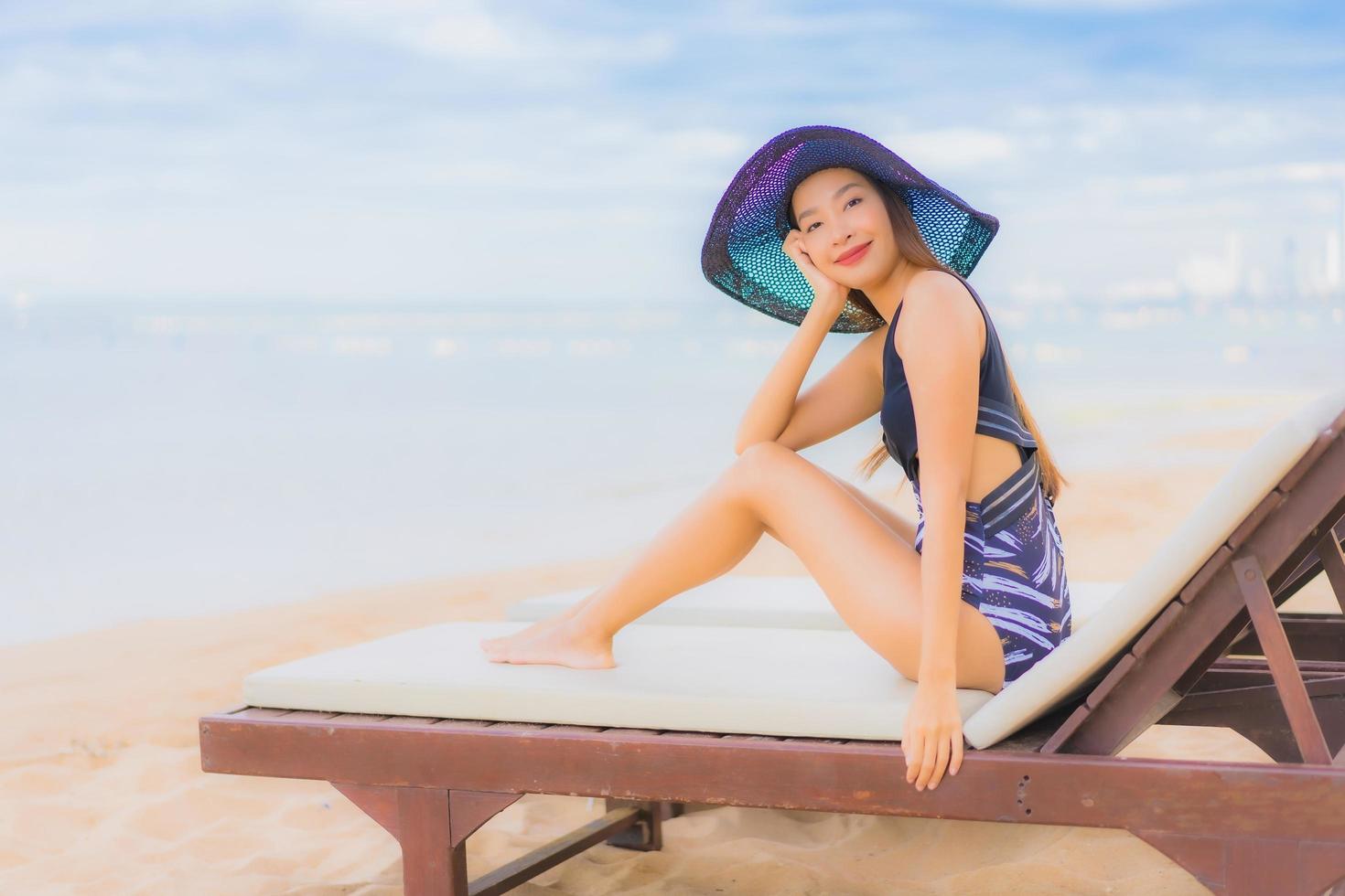 porträtt vackra unga asiatiska kvinnor koppla av leende glad runt havet stranden havet foto