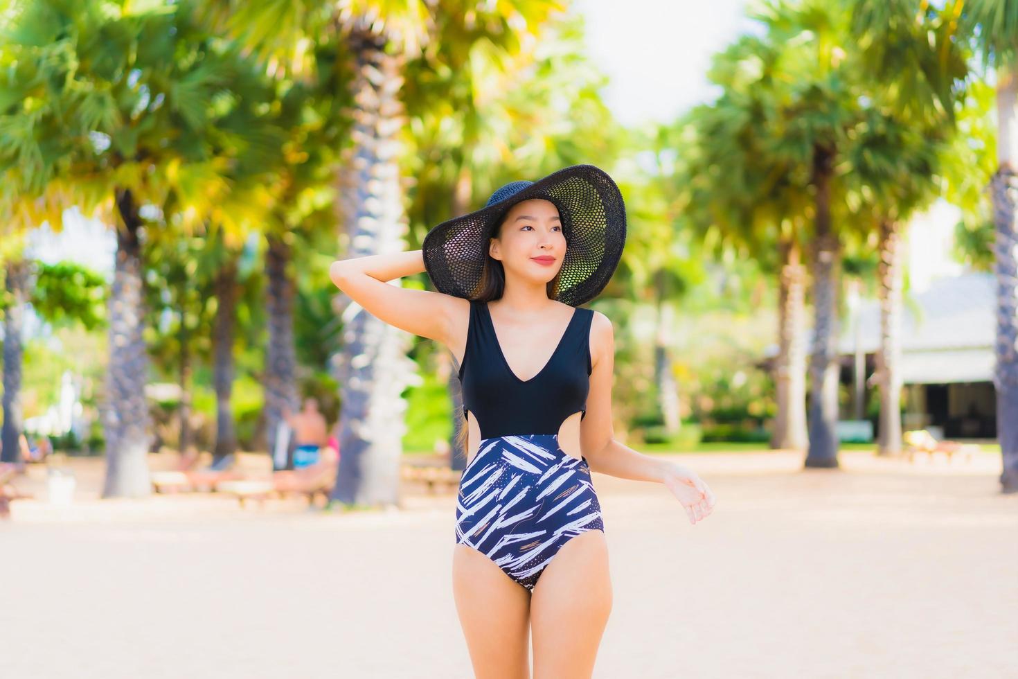 porträtt vackra unga asiatiska kvinnor koppla av leende glad runt havet stranden havet foto