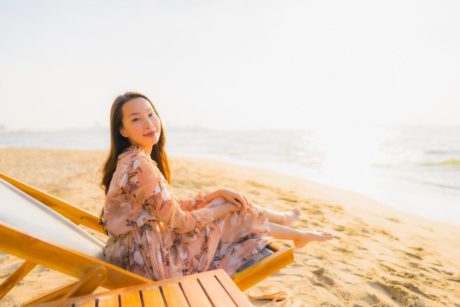 stående vackra unga asiatiska kvinnor lyckligt leende runt utomhusn lyckligt leende kopplar av runt tropiskt strandhav foto