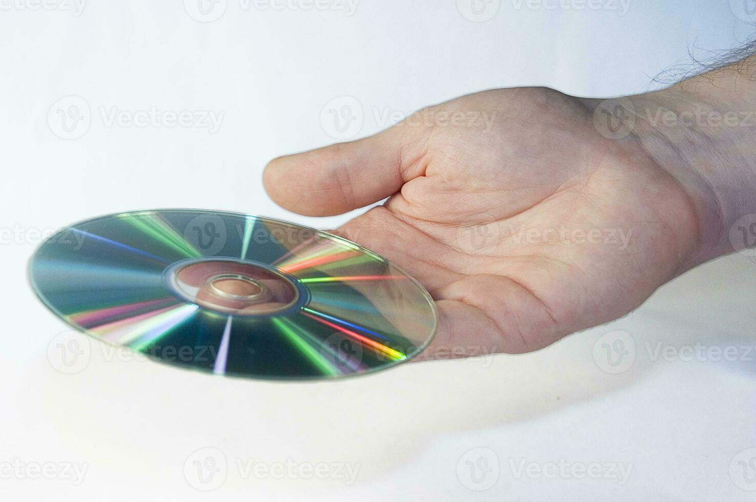 CD disk i manlig hand på vit bakgrund foto