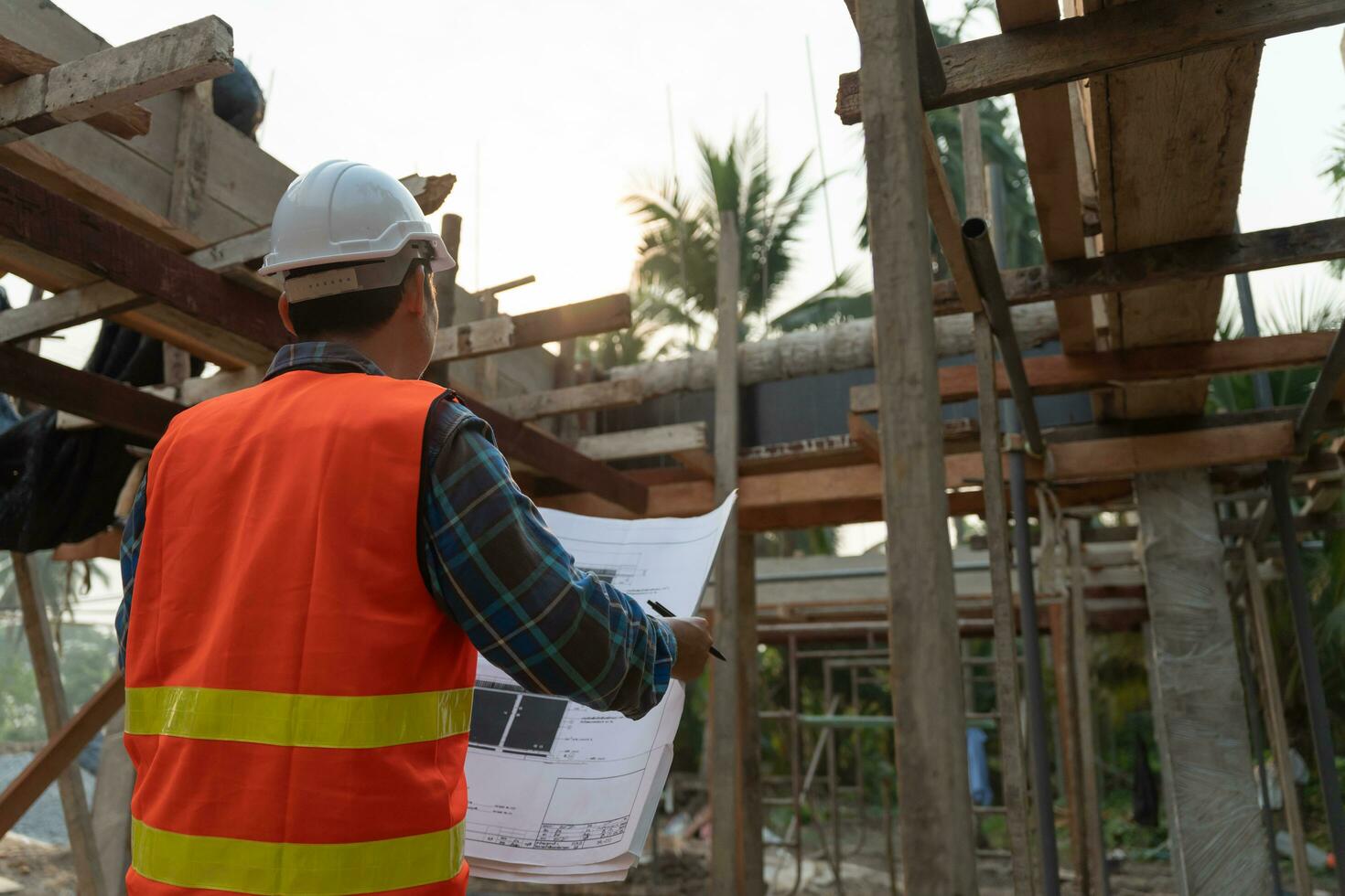 inspektör eller ingenjör är inspekterande konstruktion och kvalitet försäkran ny hus använder sig av en blå skriva ut. ingenjör eller arkitekter eller kontaktor arbete till bygga de hus innan lämnandet den över till de husägare foto