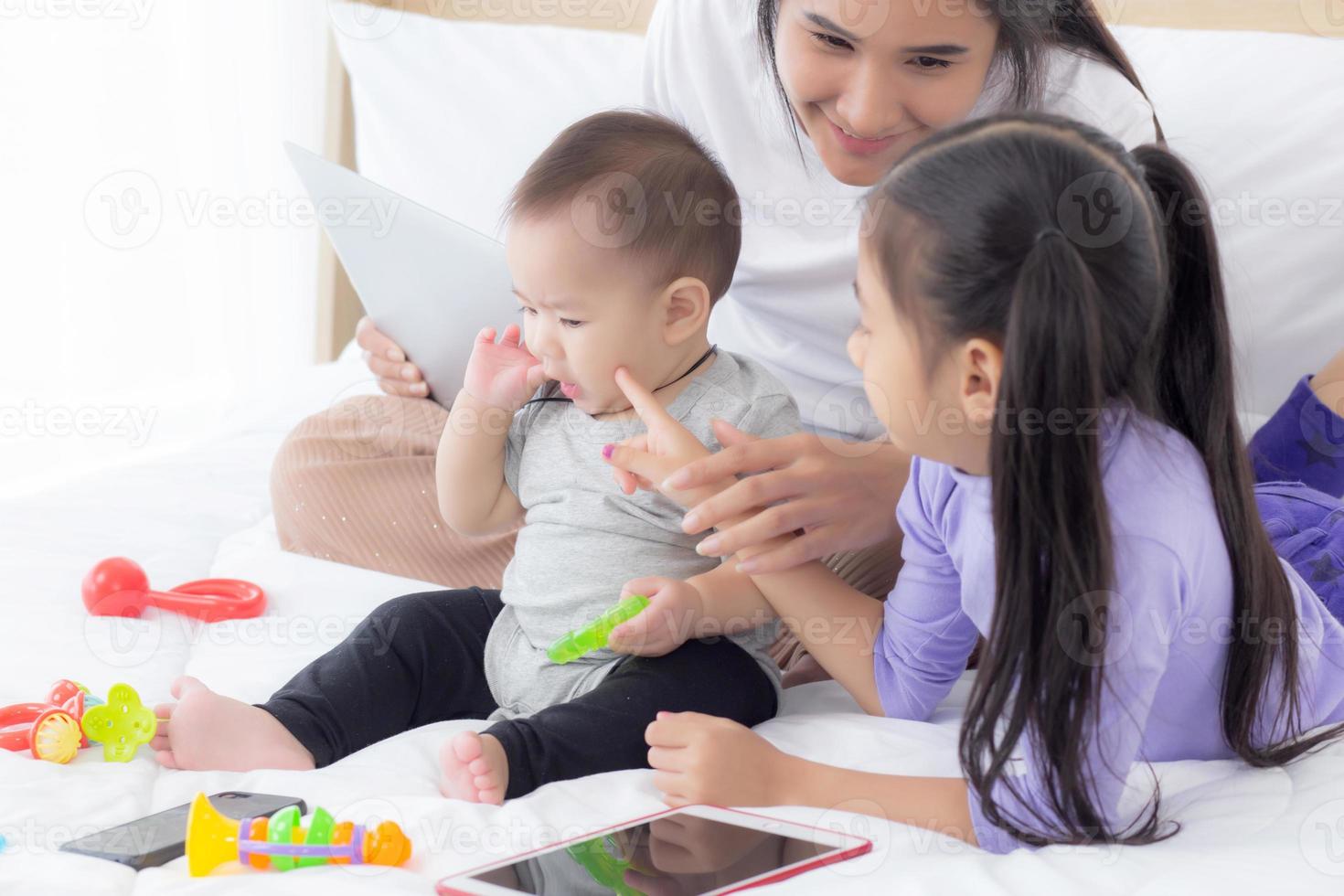 ung asiatisk mamma och babyflicka som ligger och leker på sängen tillsammans, mamma och dotter, familj av känslor och uttryck med lycklig, förälder och nyfödd slappna av och positivt, känslor och uttryck. foto