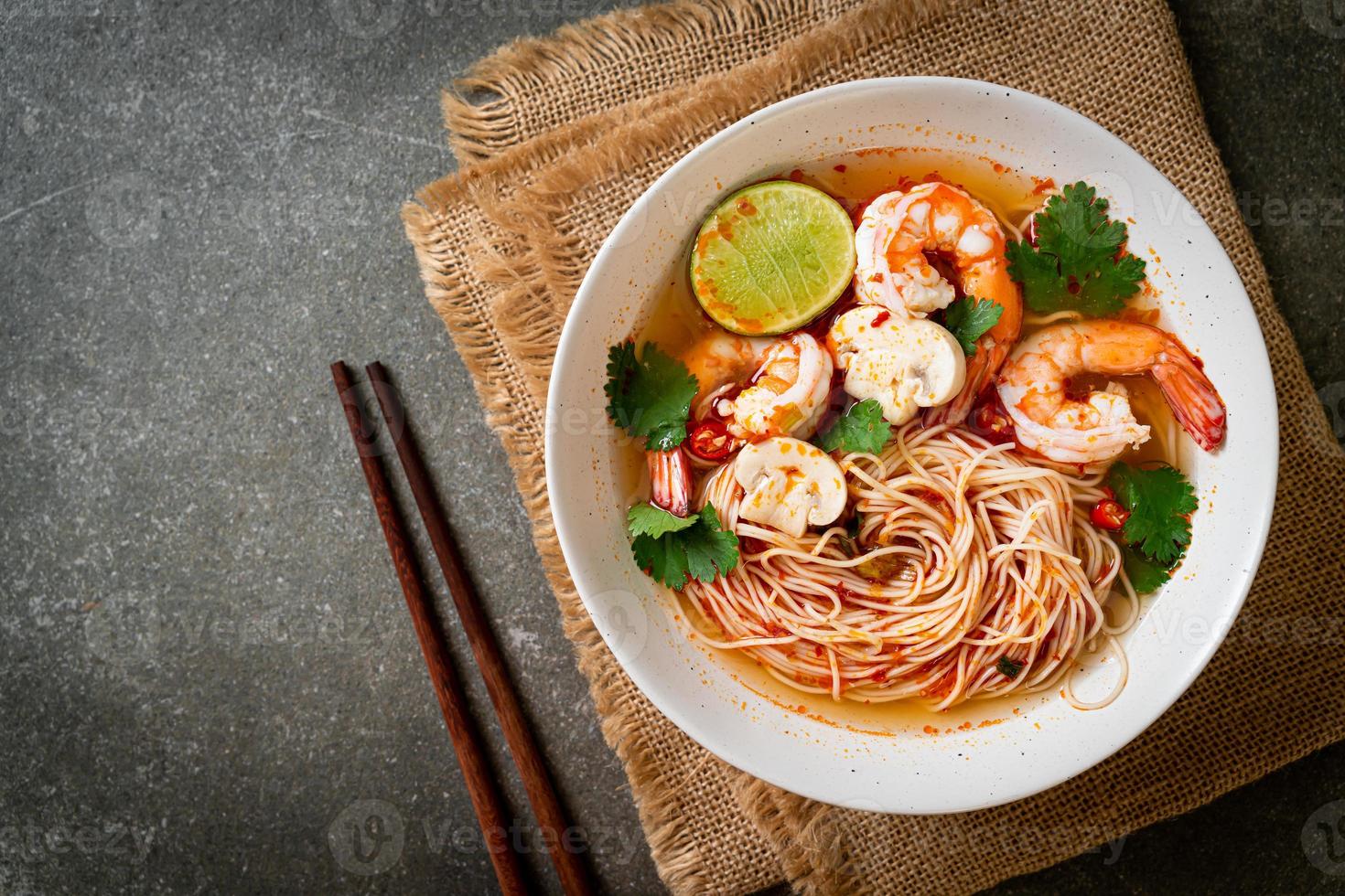 nudlar med kryddig soppa och räkor i vit skål, eller tom yum kung - asiatisk matstil foto