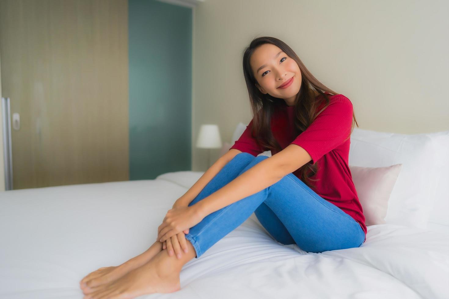 stående vackra unga asiatiska kvinnor ler glada på sängen foto