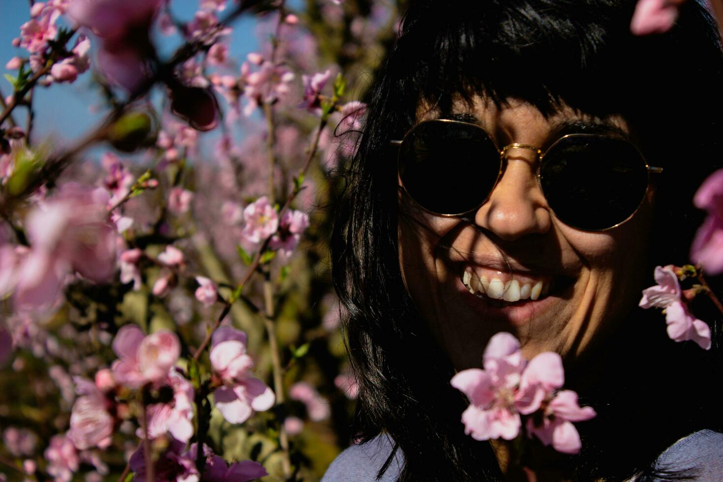 kvinna bland de Söt rosa persika träd blommor. foto