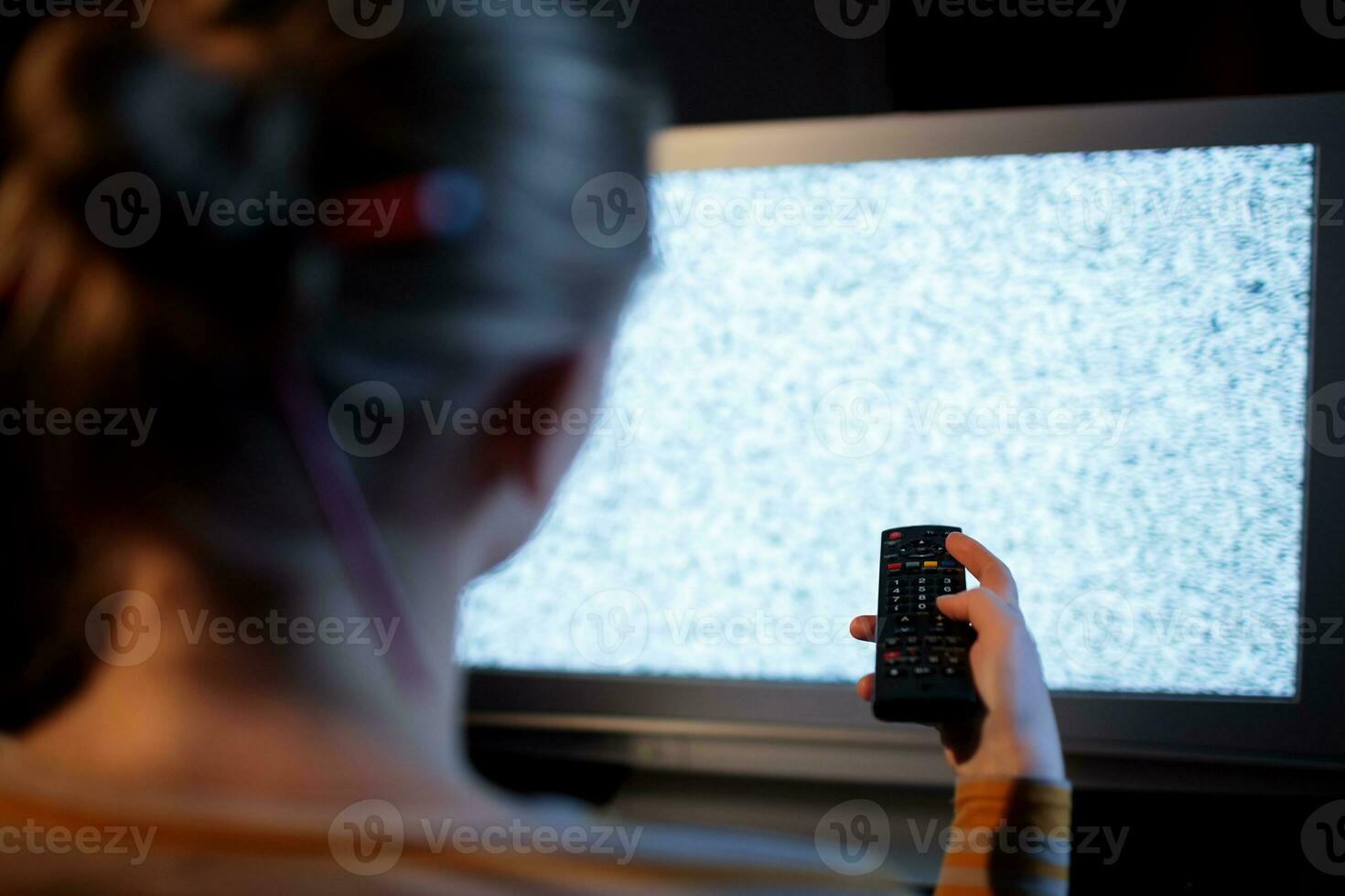 kvinna med avlägsen kontrollera i främre av TV uppsättning foto