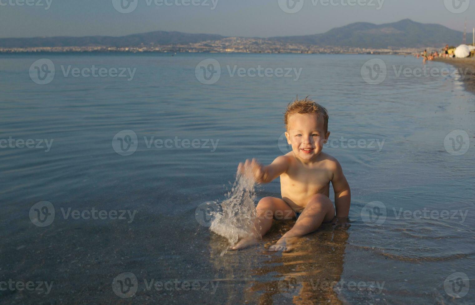 söt liten pojke stänk i de hav foto