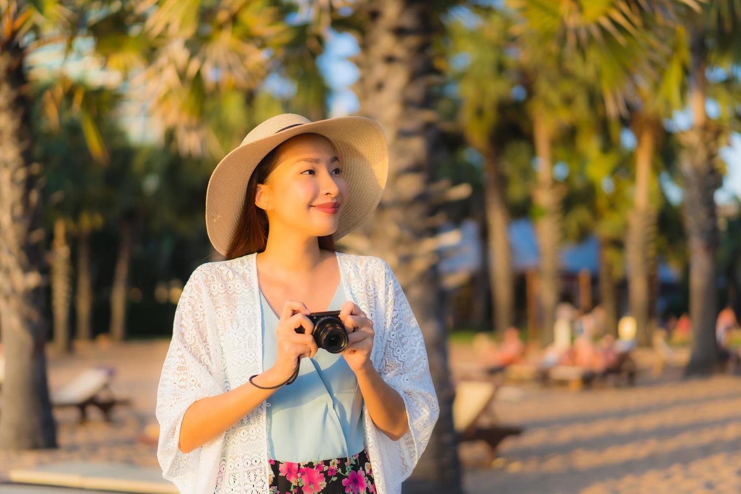 porträtt vackra unga asiatiska kvinnor lyckligt leende koppla av runt stranden havet havet foto