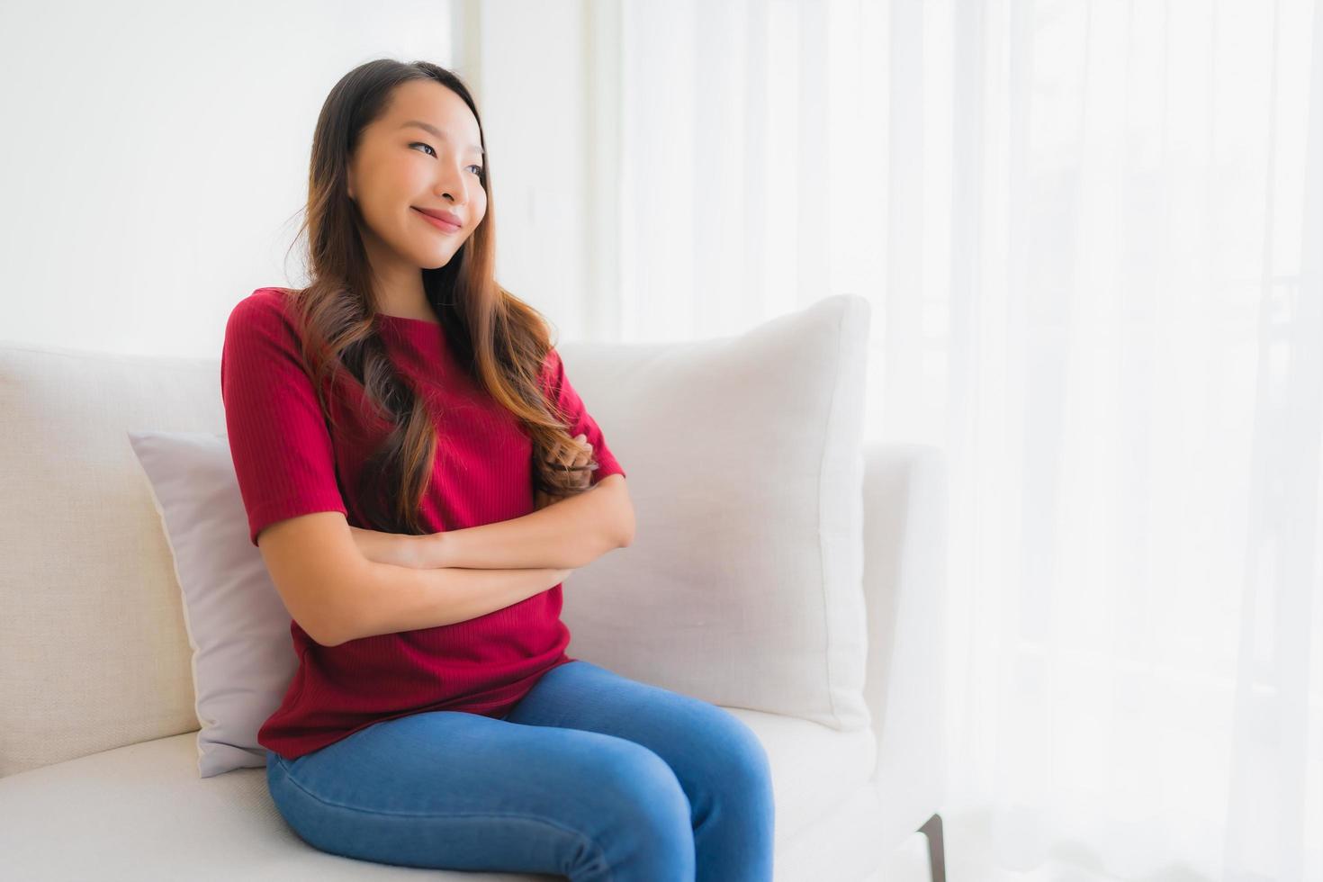 stående vackra unga asiatiska kvinnor lyckligt leende sitta på soffan foto