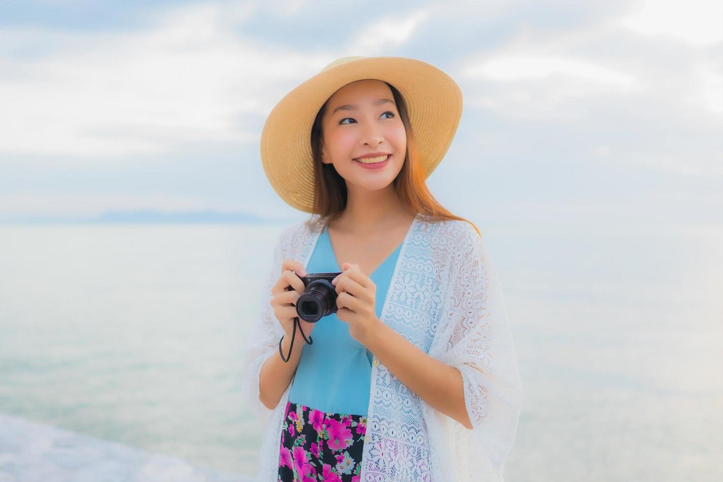 porträtt vackra unga asiatiska kvinnor lyckligt leende koppla av runt havet stranden havet foto