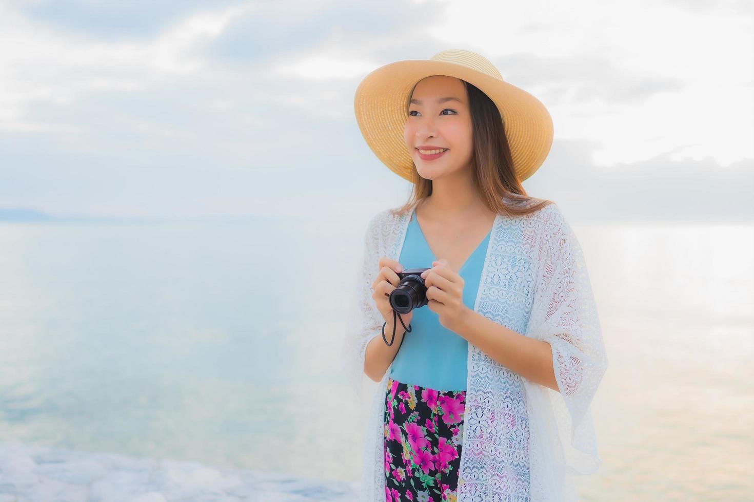 porträtt vackra unga asiatiska kvinnor lyckligt leende koppla av runt havet stranden havet foto