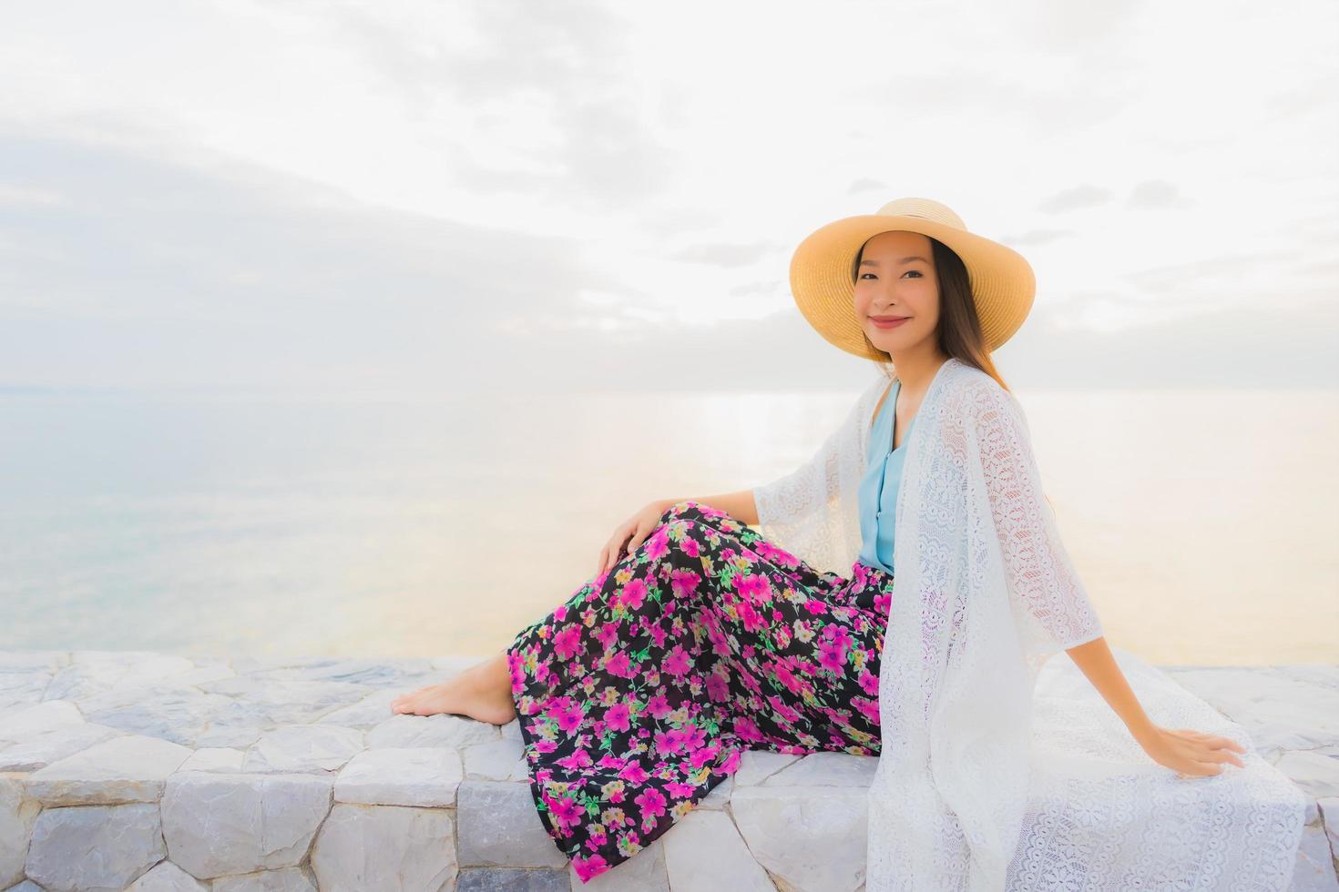 porträtt vackra unga asiatiska kvinnor lyckligt leende koppla av runt havet stranden havet foto