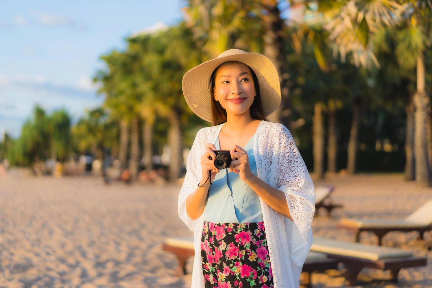 porträtt vackra unga asiatiska kvinnor lyckligt leende koppla av runt stranden havet havet foto