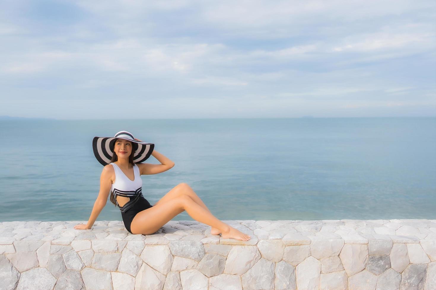 porträtt vackra unga asiatiska kvinnor koppla av leende glad runt havet stranden havet foto