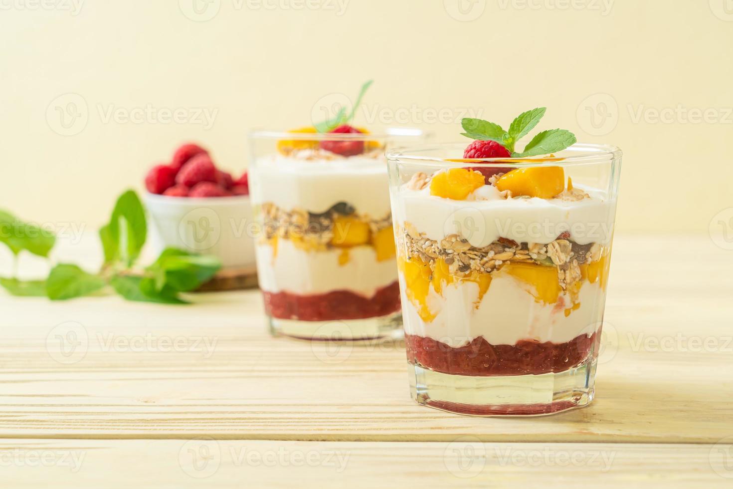 hemlagad färsk mango och färsk hallon med yoghurt och granola - hälsosam matstil foto