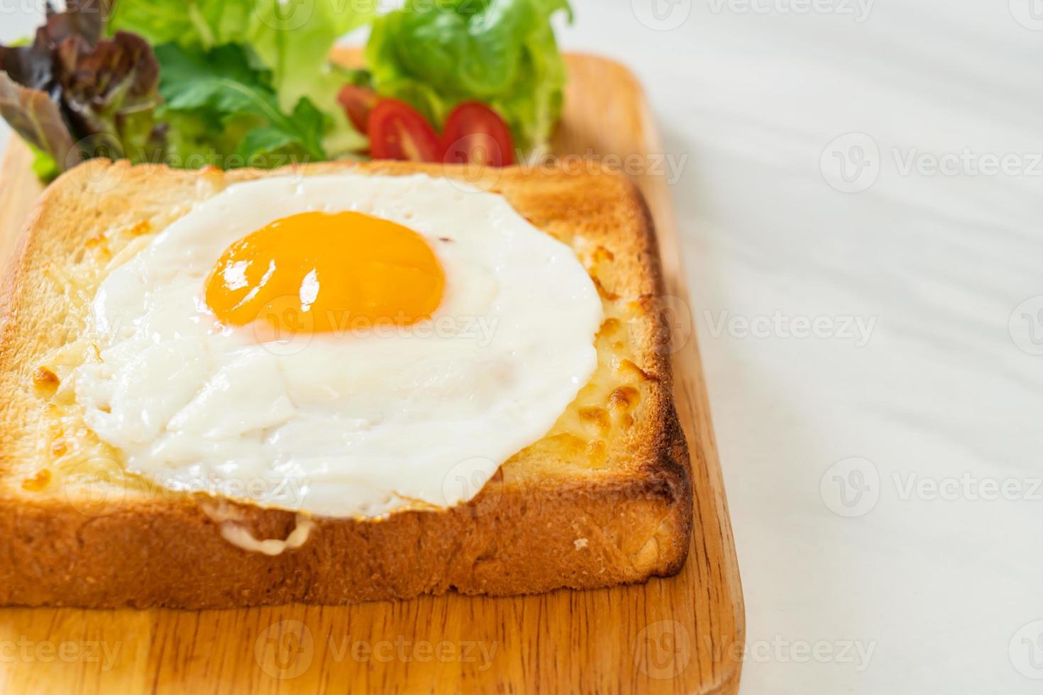 hemlagat bröd rostat med ost och stekt ägg på toppen med grönsaksallad till frukost foto