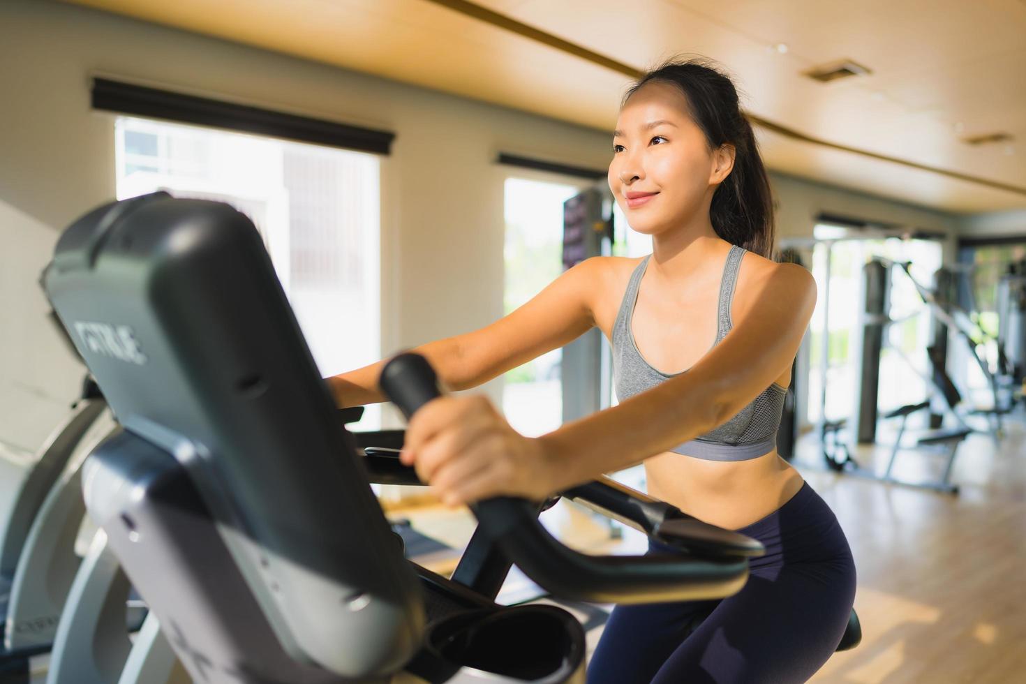 stående asiatisk kvinna som tränar och tränar i gymmet foto