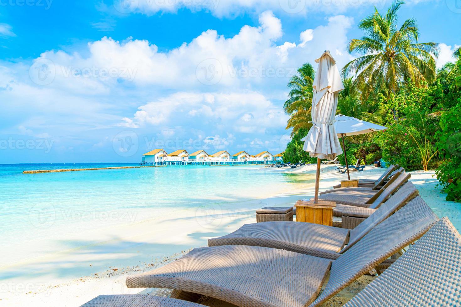 strandstolar med tropiska Maldiverna utväg hotellön och havsbakgrund foto