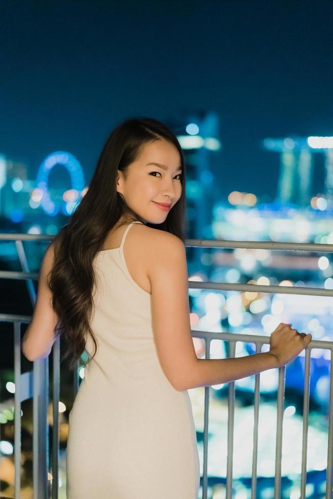 vackra asiatiska kvinnor ler och nöjda med singapore stadsutsikt foto