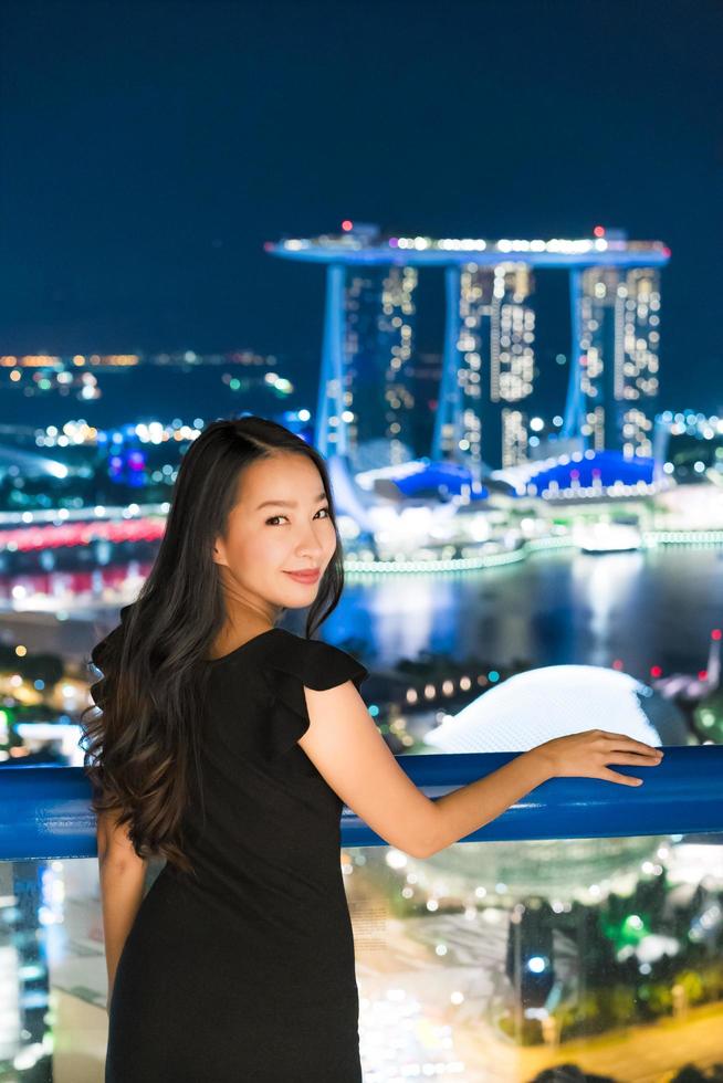 vackra asiatiska kvinnor ler och nöjda med singapore stadsutsikt foto