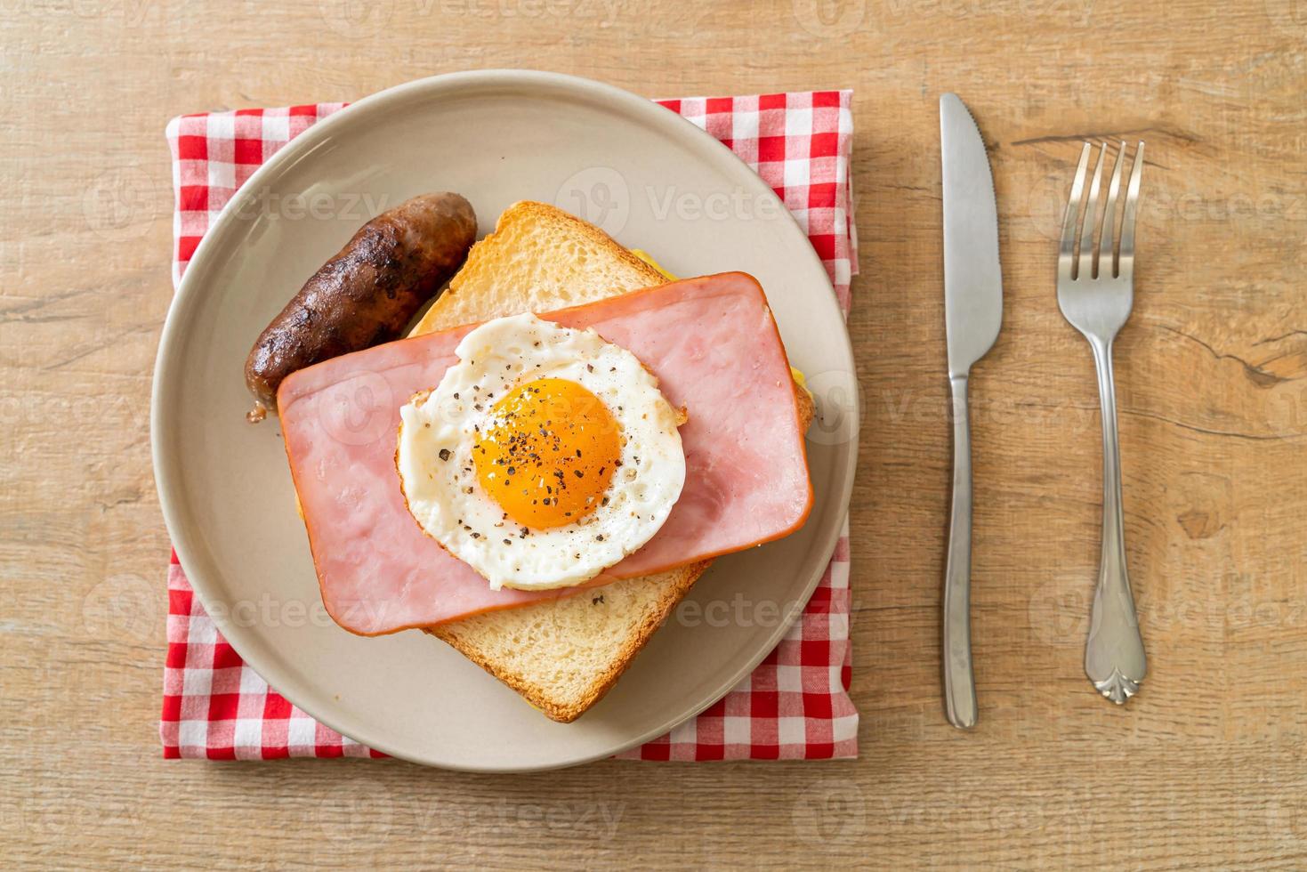 hemlagat bröd rostat ost toppad skinka och stekt ägg med fläskkorv till frukost foto