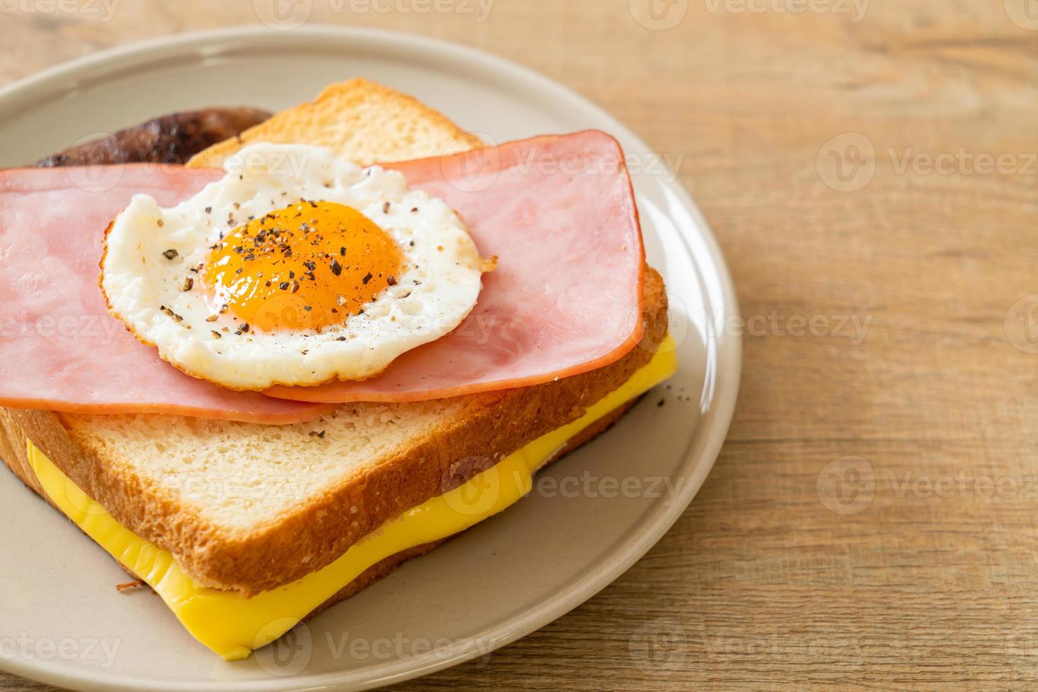 hemlagat bröd rostad ost, toppad skinka och stekt ägg med fläskkorv till frukost foto