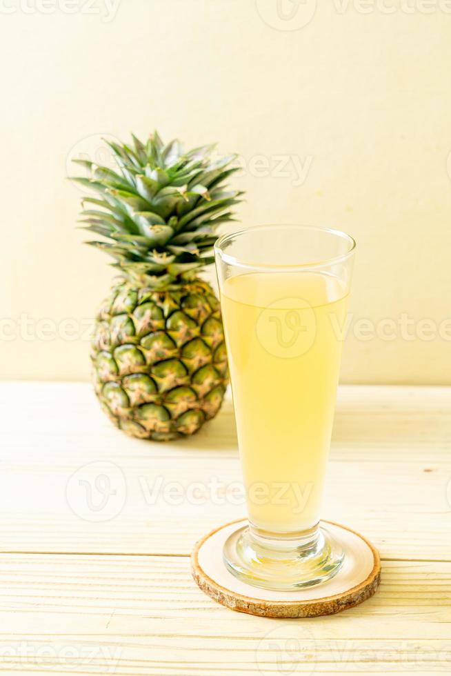 färsk ananasjuice på träbakgrund foto