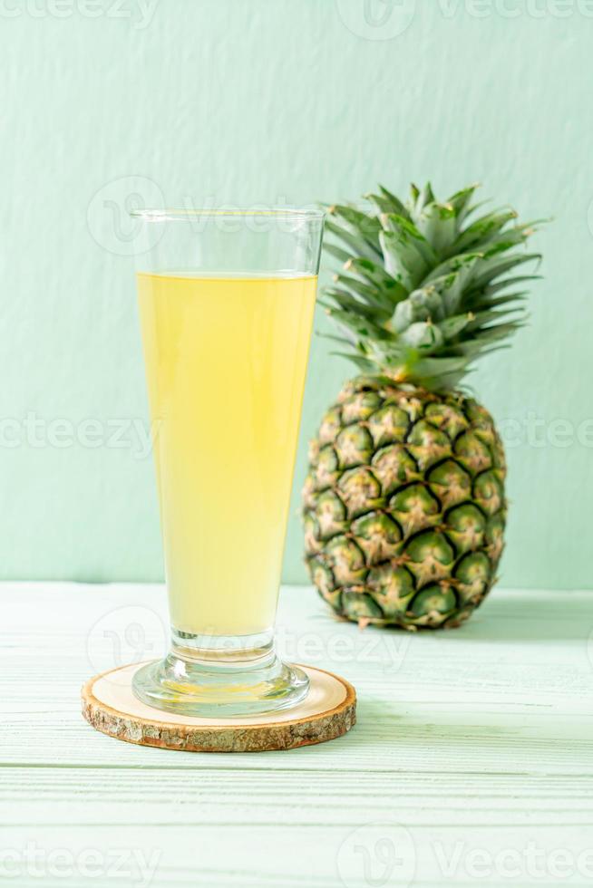 färsk ananasjuice på träbakgrund foto