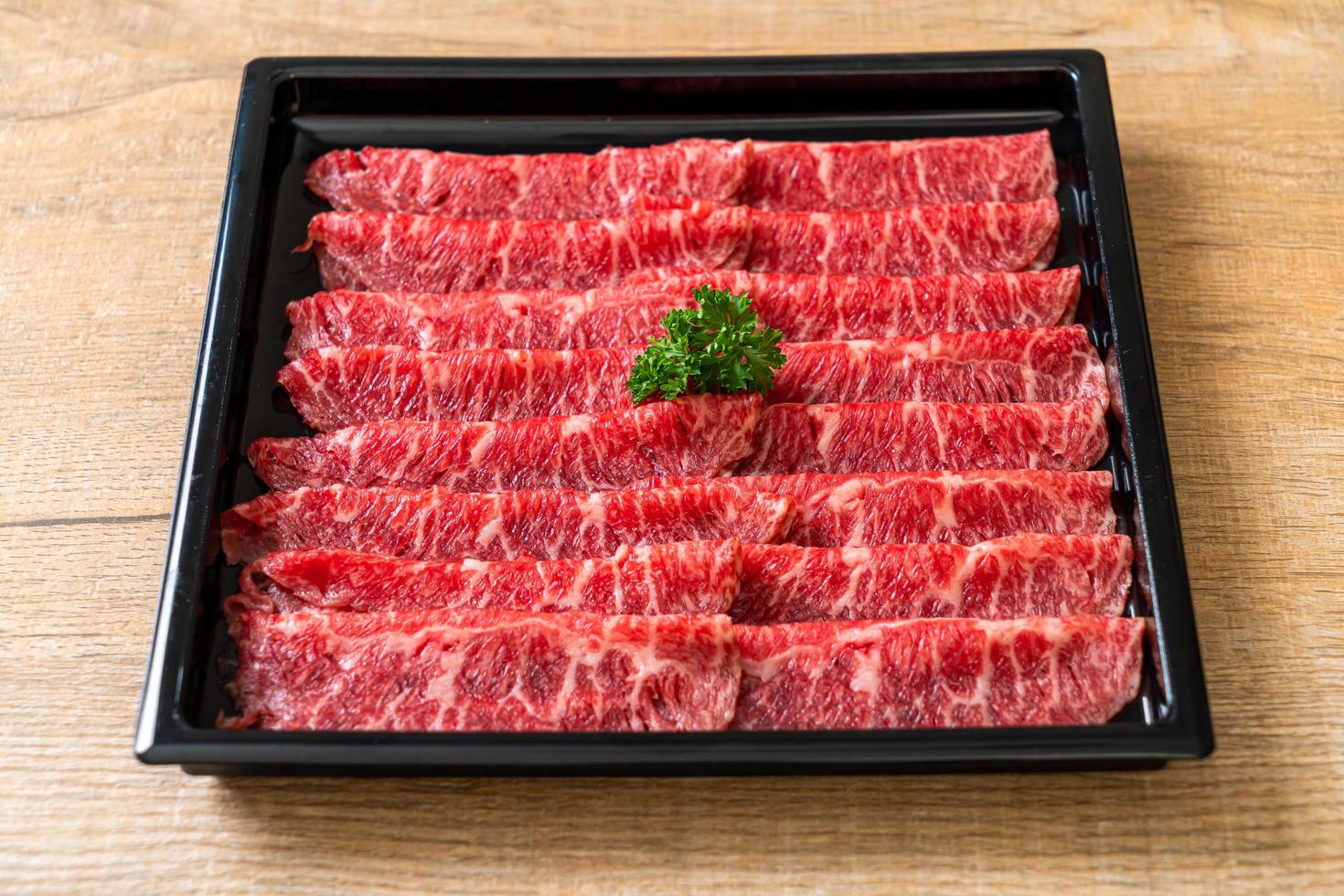färskt nötkött rå skivad med marmorerad konsistens serveras till sukiyaki och shabu eller yakiniku foto