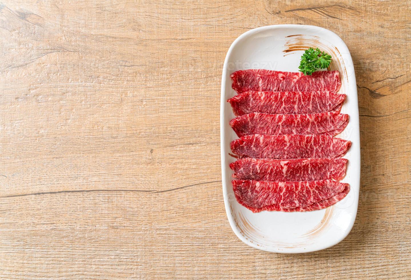 färskt nötkött rå skivad med marmorerad konsistens serveras till sukiyaki och shabu eller yakiniku foto