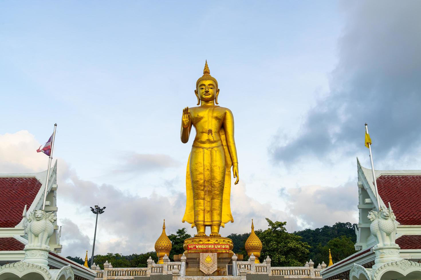 en gyllene buddha staty med himlen på bergstoppen vid hat yai kommuns offentliga park, Songkhla-provinsen, Thailand foto