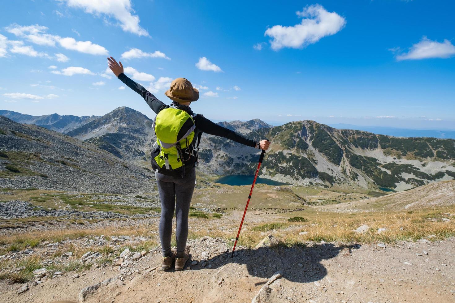 ung kvinna resenär med ryggsäck i bergen foto