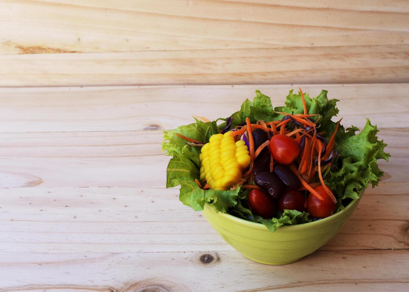 färsk grönsaksallad på träbakgrunder foto