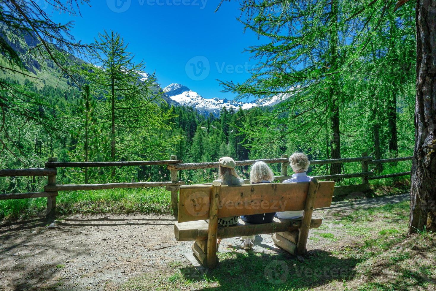 turister på en bänk i bergen kopplar av medan de betraktar utsikten foto