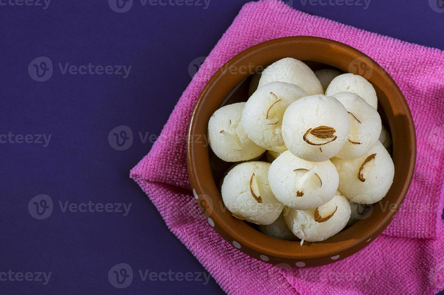 indisk söt eller efterrätt - rasgulla, berömd bengalisk söt i lerkål med blå servett på violett bakgrund foto