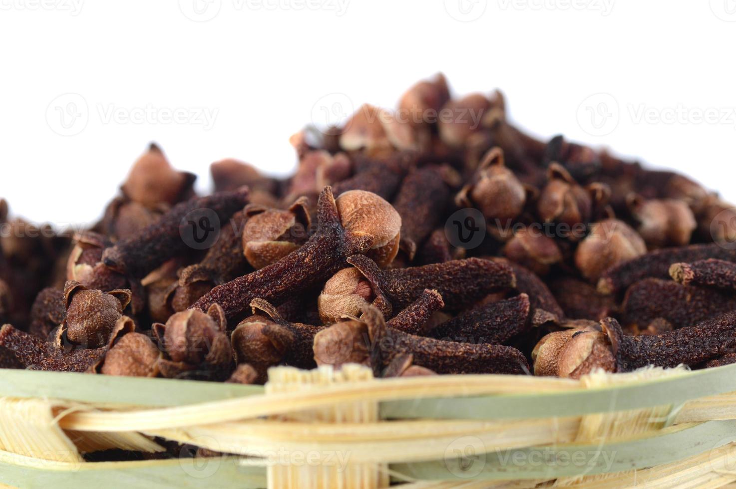 kryddnejlika kryddor i bambukorg isolerad på vit bakgrund foto