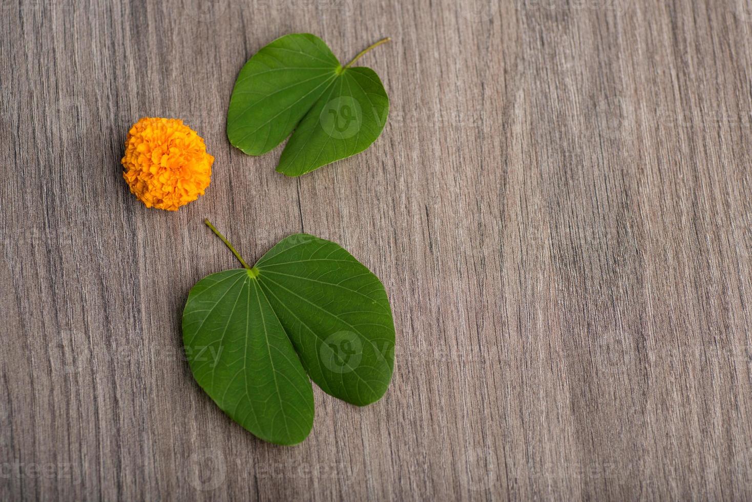 indisk festival dussehra, visar gyllene blad bauhinia racemosa och ringblomma blommor på en trä bakgrund. foto