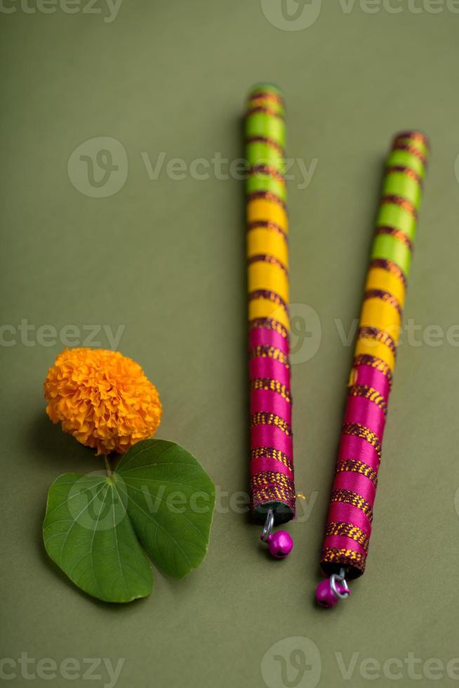 indisk festival dussehra och navratri, visar gyllene blad bauhinia racemosa och ringblomma blommor med dandiya pinnar. foto