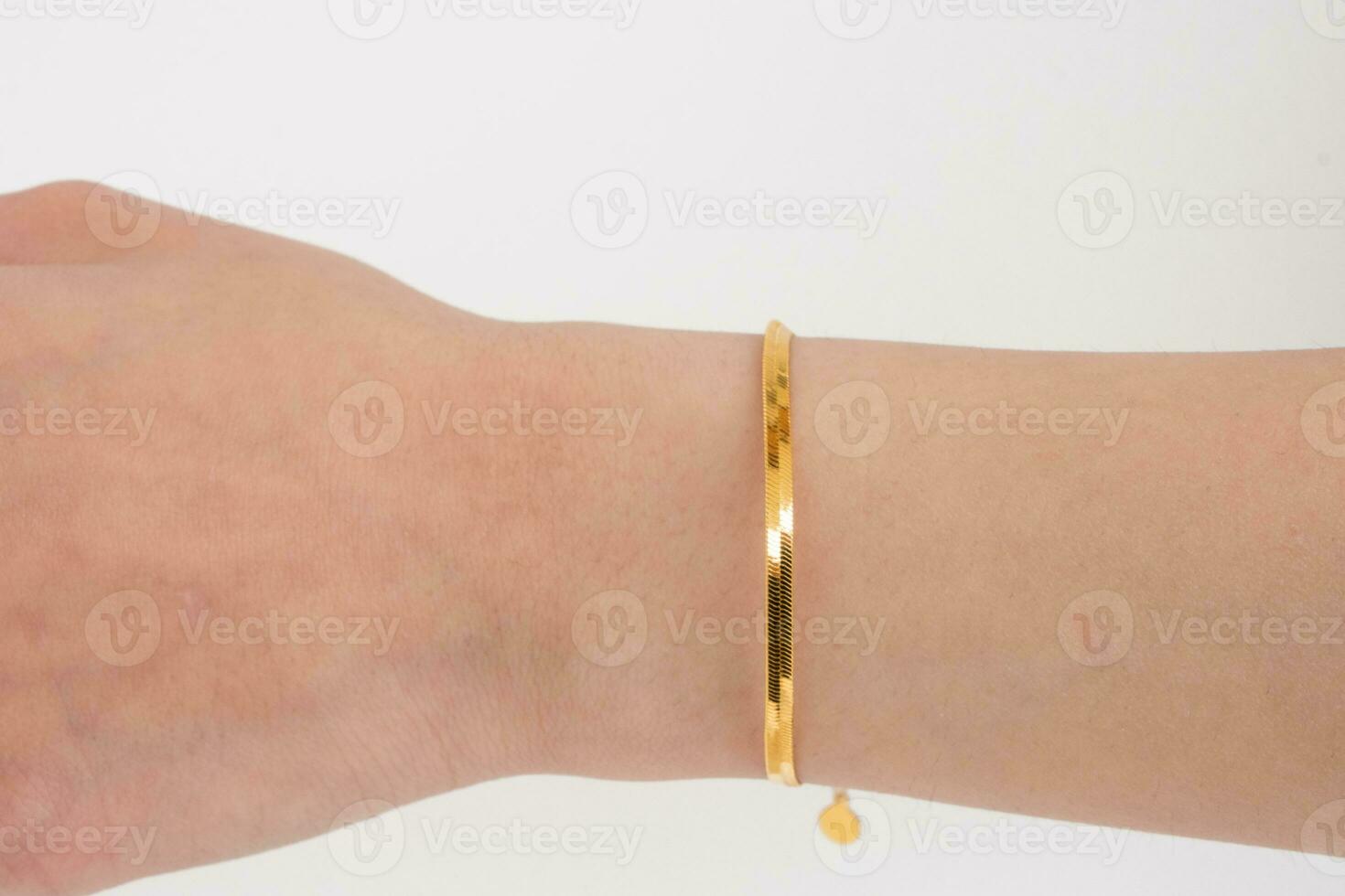 kvinna handled bär gyllene orm kedja armband uppsättning mot en vit bakgrund. skön hjärtans gåva. foto