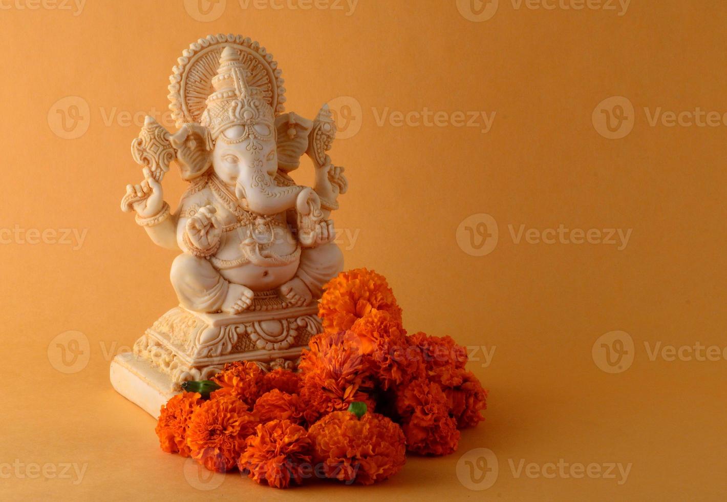 hinduiska gud ganesha. ganesha idol på gul bakgrund foto
