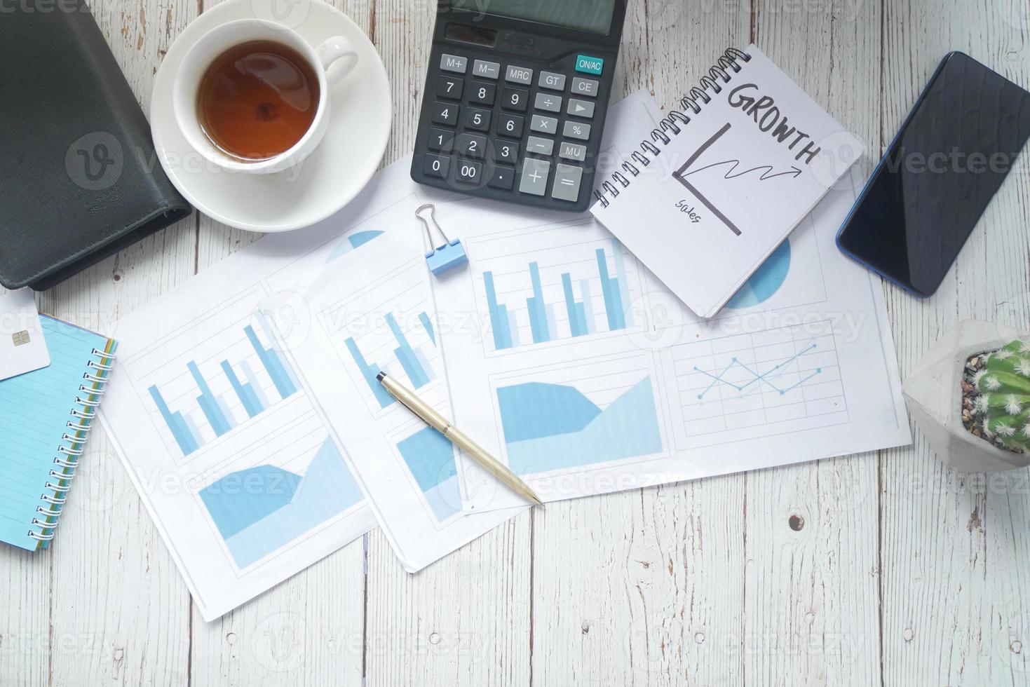 ekonomisk graf, miniräknare och anteckningar på bordet foto