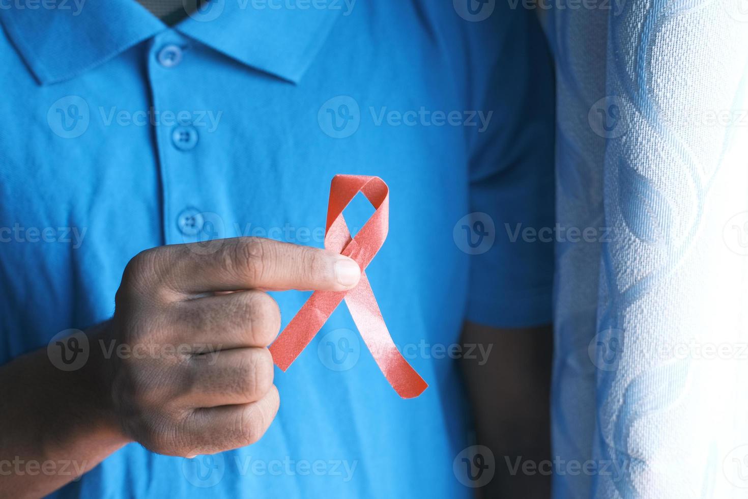 hand som håller rött hivband uppifrån och ner foto